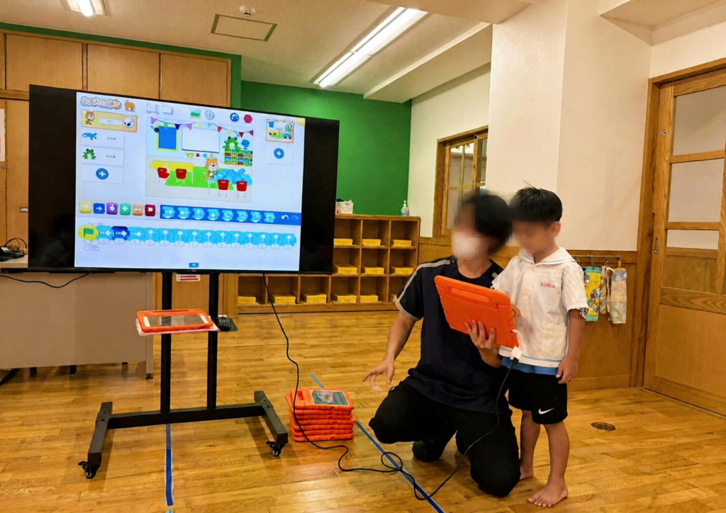 大きなモニターの前で作品を発表する様子